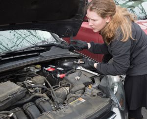 woman working on car
